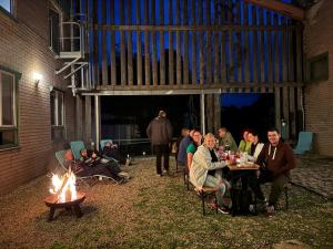 a group of people sitting around a table next to a fire at Sporthotel Streitberg in Streitberg +32 photos