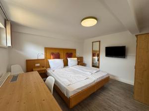 a bedroom with a large bed and a wooden table at Sporthotel Streitberg in Streitberg