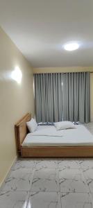 a large bed in a room with a window at 1 minute walk to Victoria Mall in Entebbe +103 photos
