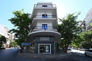 アテネにあるUrban Core Residenceの青窓のある高い白い建物