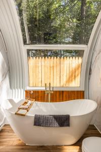 a bath tub in a bathroom with a large window at Sunken Escapes #3 Kit's Retreat in New Minas