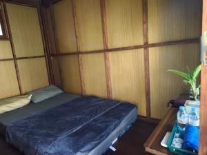 Una habitación con una cama en una habitación con paredes de madera. en Sendang Seruni Guest House, en Jambu 17 fotos más