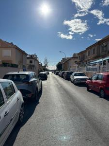 a row of cars parked on the side of a road at Casa familiar in Torrevieja