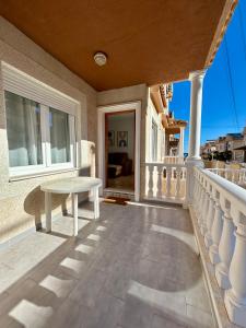 a balcony with a white table on a house at Casa familiar in Torrevieja +16 photos