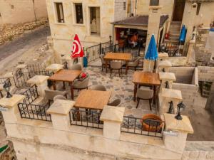 an outdoor patio with tables and chairs and umbrellas at Castle Inn Cave Cappadocia in Ortahisar