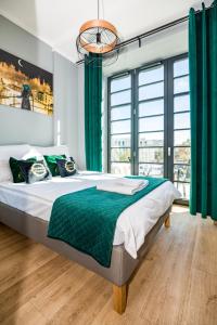 a bedroom with a large bed with green curtains at Rezydencja Wrocław Centrum in Wrocław