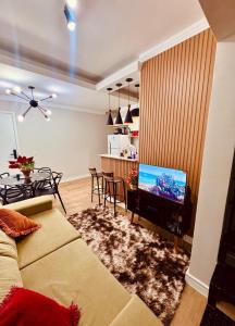 ein Wohnzimmer mit Sofa und Fernseher in der Unterkunft Cobertura LUHNA - 3 Quartos-Ar Condicionado-Vista Cidade-6 Pessoas in Salto