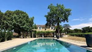 a swimming pool in front of a house at La Maison du Vignoble piscine, tennis, Wallbox in Lectoure
