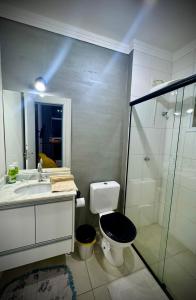 ein Badezimmer mit Toilette, Waschbecken und Dusche in der Unterkunft Cobertura LUHNA - 3 Quartos-Ar Condicionado-Vista Cidade-6 Pessoas in Salto + 22 Fotos