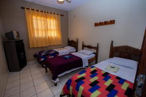 a room with two beds and a tv in it at Pousada Zacarias in Ouro Preto