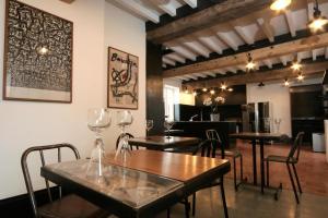 a dining room with tables and chairs with wine glasses at La Maison du Vignoble piscine, tennis, Wallbox in Lectoure