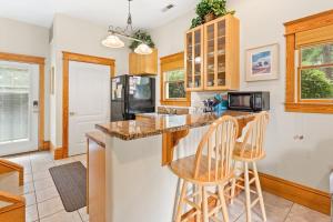 a kitchen with a counter and two bar stools at IC1 - Little Lifeboat House in Manteo +20 photos