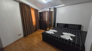 a bedroom with a black bed with two white pillows at Terrace & Comfort Residence- SELF CHECK-IN in Bucharest