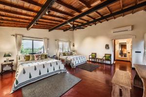 a living room with two beds and a couch at SaffronStays Satori Hornbill, Ultra Luxe two bedroom Villa on 8 Acres Estate, By The Mulshi Lake in Mulshi +38 photos