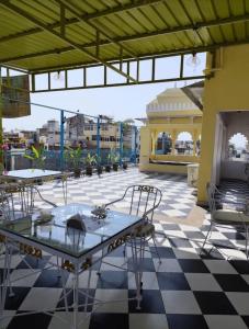 un patio con mesas y sillas en un suelo a cuadros en Haveli near the lake, en Udaipur