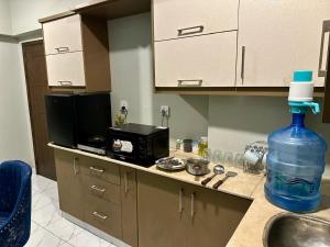 a kitchen with a bottle of water and a microwave at Beachfront Studios by Virani in Karachi