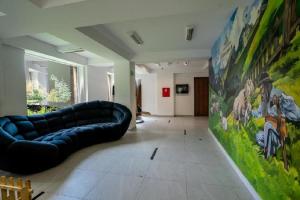 a living room with a couch and a painting on the wall at Kozubnik Apartment in Porąbka