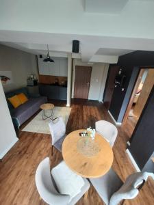 a living room with a table and white chairs at Kozubnik Apartment in Porąbka