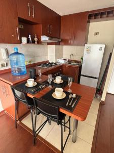 a kitchen with a table with chairs and wine glasses at Experiencia Terramar-1hab-1Bañó-1estac in Antofagasta