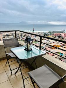 a table on a balcony with a view of the ocean at Experiencia Terramar-1hab-1Bañó-1estac in Antofagasta