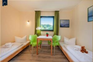 a room with two beds and a table and chairs at Lindenstraße Ferienwohnung Anker in Ostseebad Koserow