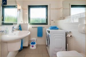 a white bathroom with a sink and a toilet at Lindenstraße Ferienwohnung Anker in Ostseebad Koserow +19 photos