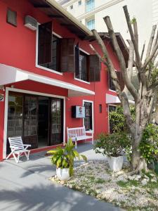 a red building with a tree in front of it at Pousada Ana Julia in Florianópolis