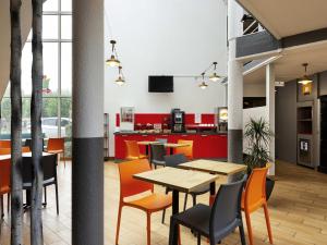 a dining room with tables and chairs and red cabinets at Hôtel F1 Reims Tinqueux in Reims