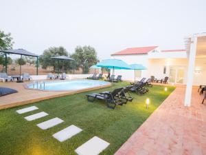 a backyard with a pool and chairs and umbrellas at Tavira Monte in Tavira