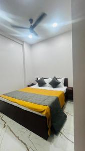 a bedroom with a bed with a yellow blanket at Sri Krishna Guest House in Nashik