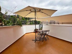a table and chair with an umbrella on a balcony at Rincón cálido in Adeje