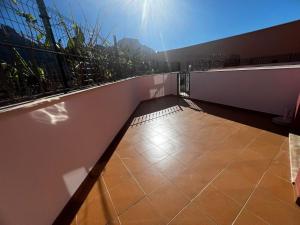 a balcony with a tile floor next to a white wall at Rincón cálido in Adeje +6 photos