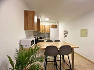 a kitchen with a wooden table and some chairs at Rincón cálido in Adeje