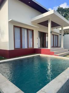 a house with a swimming pool in front of it at Permata Villas Lombok in Kuta Lombok