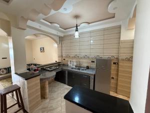 a large kitchen with a black counter and appliances at la perle rare de Sidi Ifni in Sidi Ifni