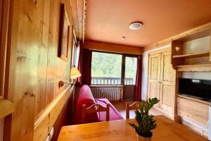 ein Esszimmer mit einem Tisch und einem Fenster in der Unterkunft Second de Cordée in Combloux