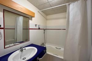 ein Badezimmer mit Waschbecken, Spiegel und Badewanne in der Unterkunft Second de Cordée in Combloux