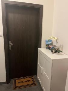 a black door in a room with a white refrigerator at Apartmán Husova in Prachatice
