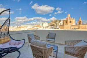 Un balcón con sillas y vista a una ciudad. en Stella Maris - 'Star of the Sea' Penthouse-Sliema, en Sliema
