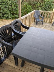 een picknicktafel en twee stoelen op een terras bij Mobil home Phoenix 6 places in La Boissière-de-Montaigu