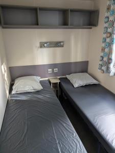 two beds in a small room with one at Mobil home Phoenix 6 places in La Boissière-de-Montaigu