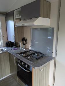 a kitchen with a stove and a counter top at Mobil home Phoenix 6 places in La Boissière-de-Montaigu