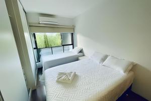 een kleine slaapkamer met een bed en een stoel bij Studio ao lado do Parque da Cidade - Brasília in Brasilia