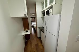 een keuken met een koelkast en een magnetron bij Studio ao lado do Parque da Cidade - Brasília in Brasilia +37 foto's