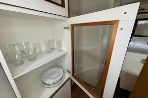 een badkamer met een toilet en glazen op een plankje bij Studio ao lado do Parque da Cidade - Brasília in Brasilia