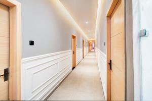 a hallway with white walls and wooden doors at OYO 8303 Hotel SS Royal in Transport Nagar