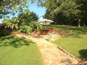 patio con ombrellone e tavolo in cortile di Clos de Fougères - La Grange 4-5 personnes a Montoillot