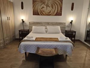 a bedroom with a large bed with two side tables at Casa Rural Montevive in Alhendín +30 photos