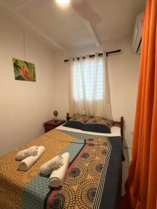 a bedroom with a bed with towels on it at Kaz à Zozio - F2 au calme à Bouillante in Bouillante
