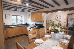 a kitchen with a table and a dining room at The Shippon Barn - A delightful haven for families in Wirral